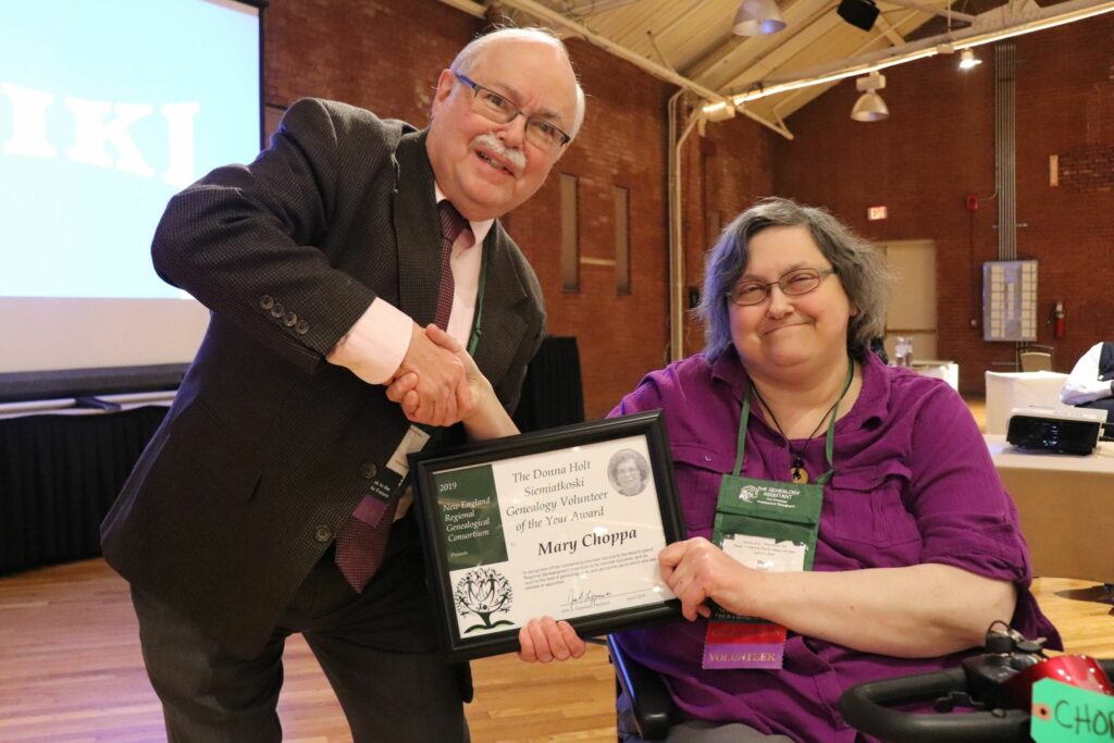 Photo of Mary Choppa, being presented with the Donna Holt Siemiatkoski Genealogy Volunteer of the Year Award by John Leppman at the 2019 NERGC Conference.