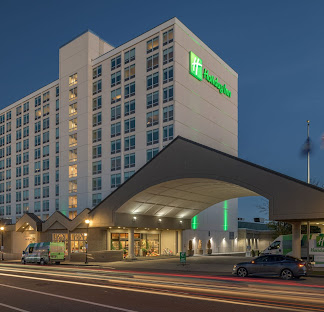 10 story building with low arch for entrance, with sign on the side of the building saying Holiday Inn